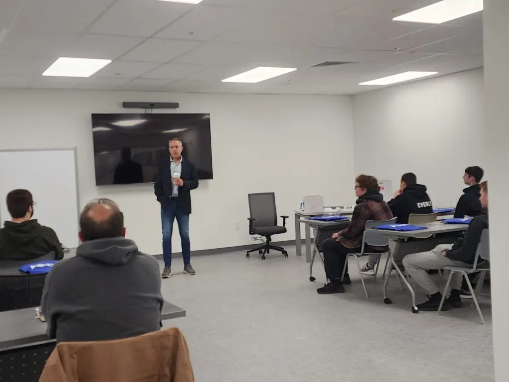 John speaking to a group of students