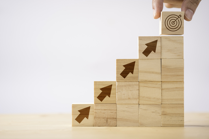 increasingly taller columns of wooden blocks with arrows leading up to a target block